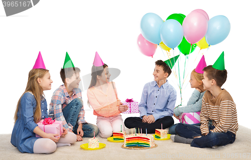 Image of happy children giving presents at birthday party