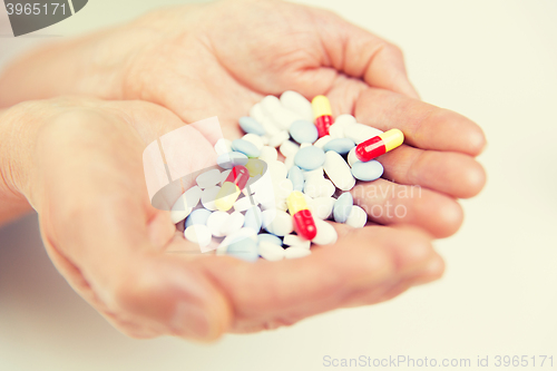 Image of close up of senior woman hands with pills