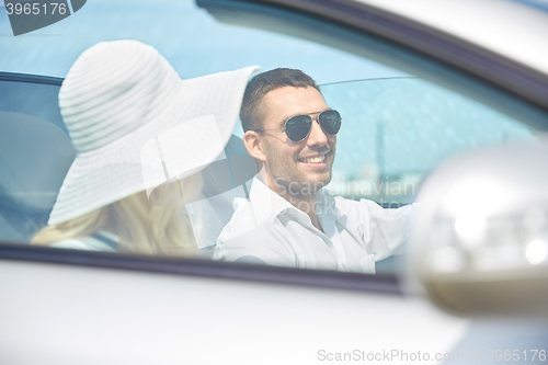 Image of happy man and woman driving in cabriolet car