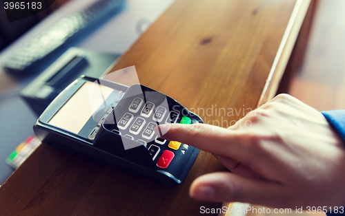 Image of hand entering password to bank terminal