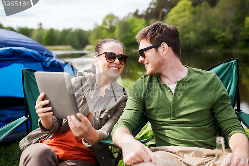 Image of happy couple with tablet pc at camping tent