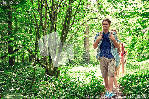 Image of group of smiling friends with backpacks hiking