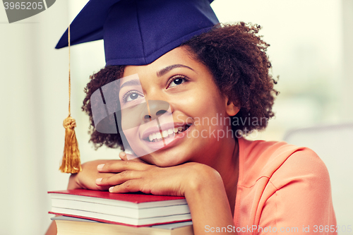 Image of happy african bachelor girl with books at home