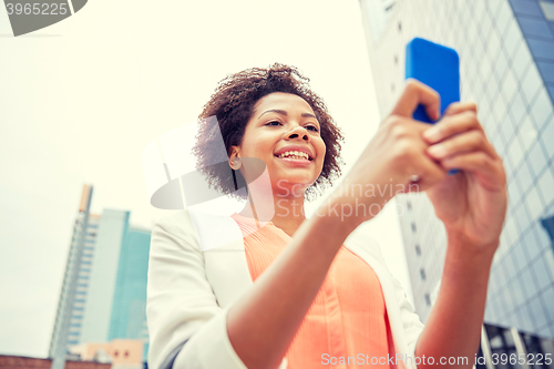 Image of happy african businesswoman with smartphone