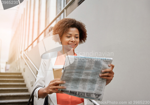 Image of happy african businesswoman with coffee in city