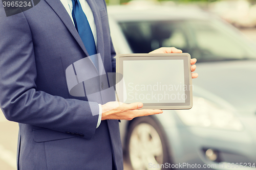 Image of close up of young man with tablet pc and car