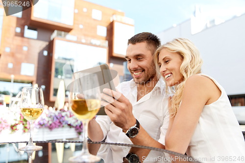 Image of happy couple with tablet pc at restaurant terrace