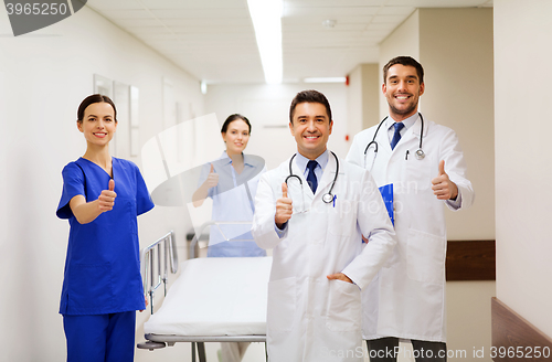 Image of happy doctors showing thumbs up at hospital