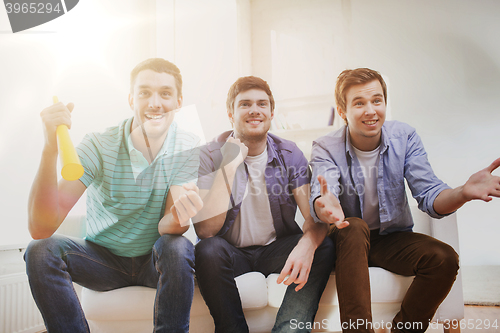 Image of happy male friends with vuvuzela