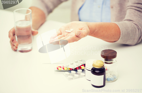 Image of close up of senior woman with pills and water 