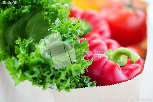 Image of close up of paper bag with vegetables and greens