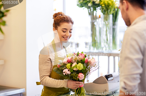 Image of smiling florist woman and man at flower shop