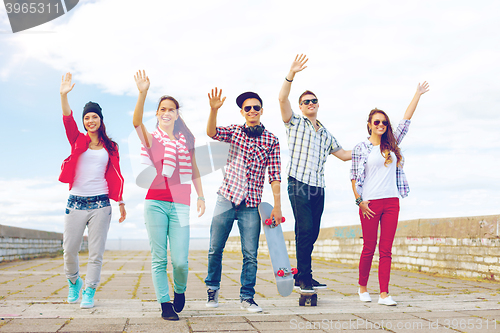 Image of group of smiling teenagers waving hands