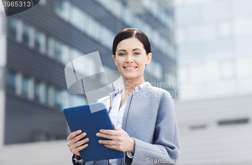 Image of smiling business woman with tablet pc in city