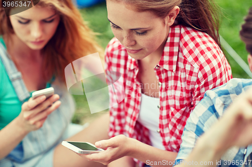 Image of friends with smartphone at camping