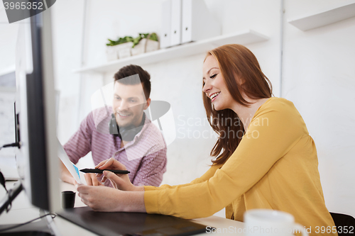 Image of happy creative team with papers at office