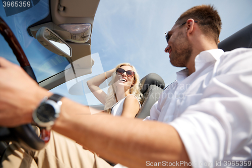 Image of happy man and woman driving in cabriolet car