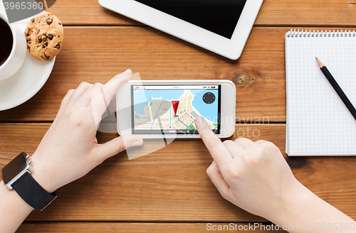 Image of close up of woman with smartphone on wooden table