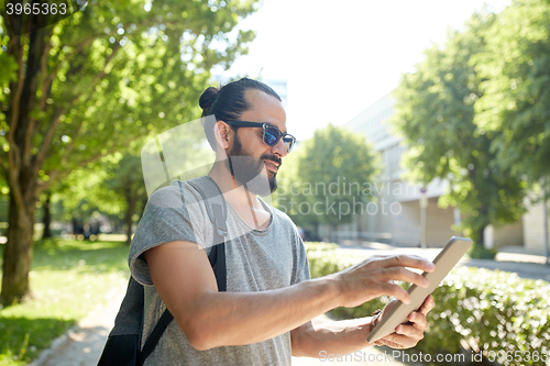 Image of man traveling with backpack and tablet pc in city