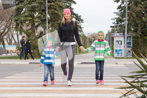 Image of Anapa, Russia - March 9, 2016: a young mother with two daughters cross the road at a pedestrian crossing