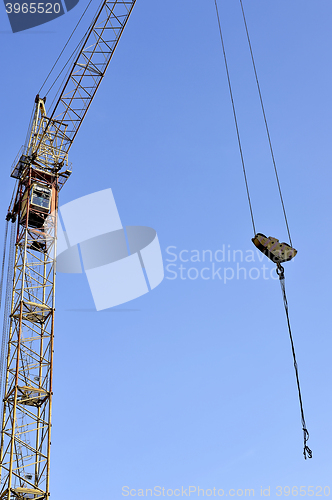 Image of Crane and building construction site against blue sky