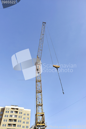 Image of Crane and building construction site against blue sky