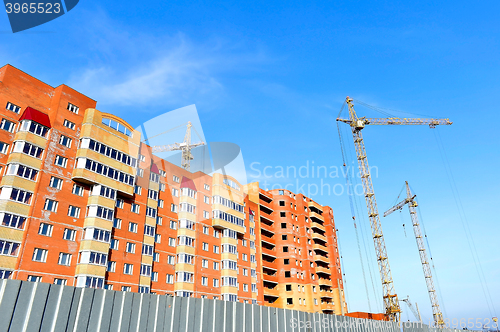 Image of Crane and building construction site against blue sky