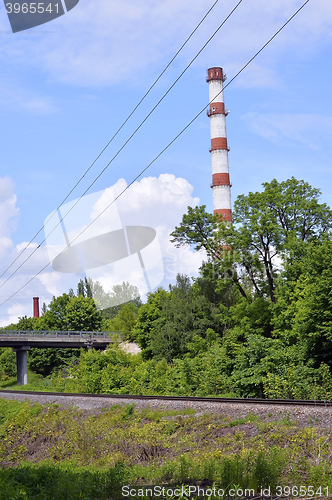 Image of Industrial boiler pipe on a background of green trees