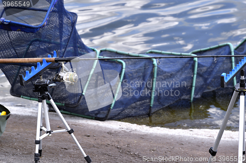 Image of Chair with fishing poles and fishing equipment at the lake