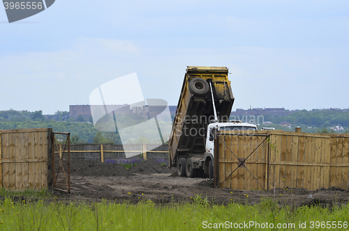 Image of Big old tipper vith clay ground dumped soil in storage space