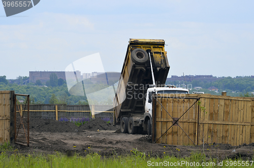 Image of Big old tipper vith clay ground dumped soil in storage space