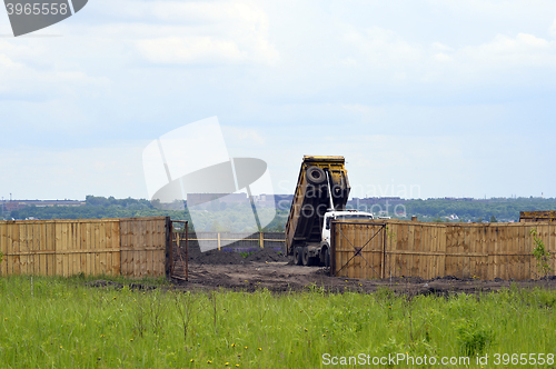 Image of Big old tipper vith clay ground dumped soil in storage space
