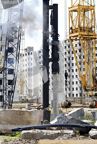 Image of Mechanism scores piles at construction site