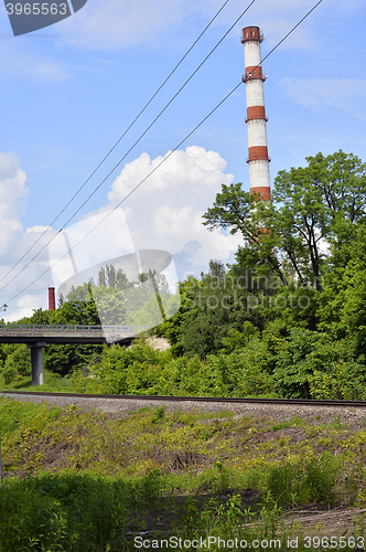 Image of Industrial boiler pipe on a background of green trees