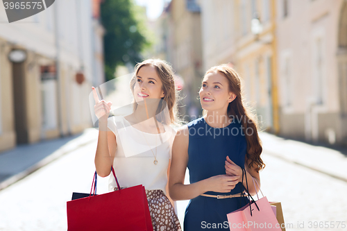 Image of happy women with shopping bags in city