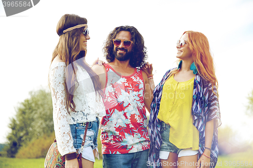 Image of smiling young hippie friends talking outdoors