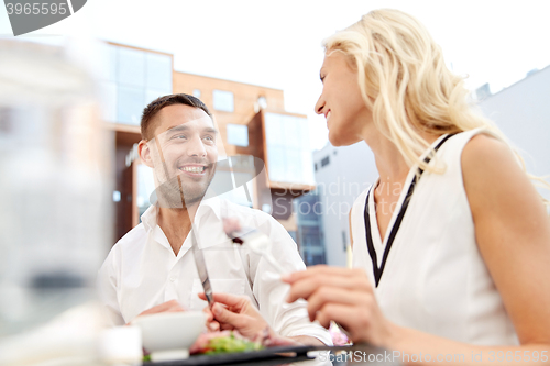 Image of happy couple eating dinner at restaurant terrace