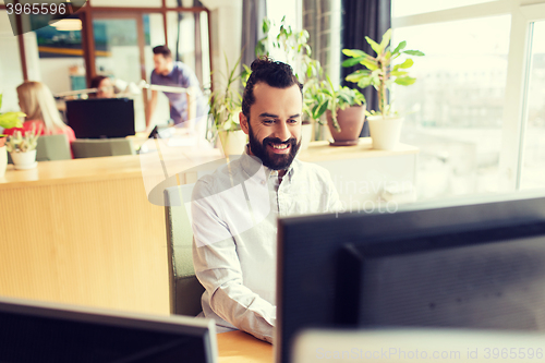 Image of happy creative male office worker with computer