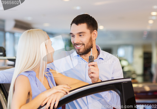 Image of happy couple buying car in auto show or salon