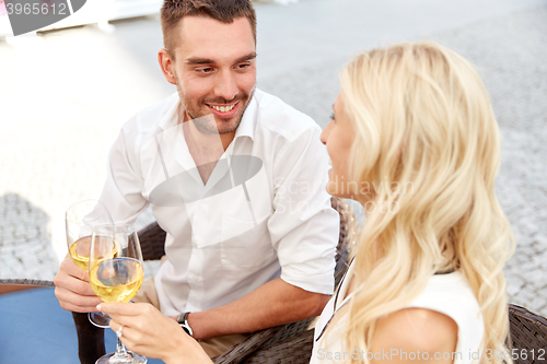 Image of happy couple drinking wine at open-air restaurant