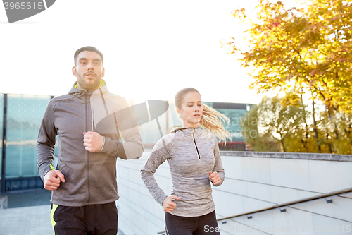 Image of happy couple running upstairs on city stairs