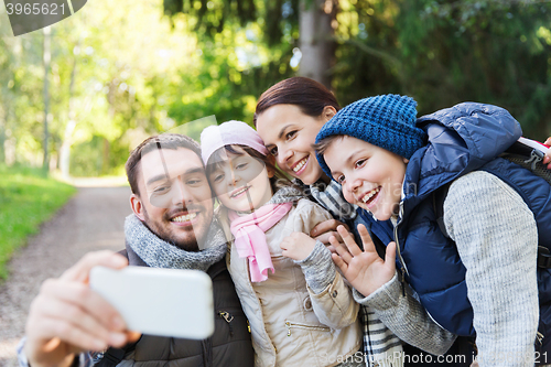 Image of family with backpacks taking selfie by smartphone