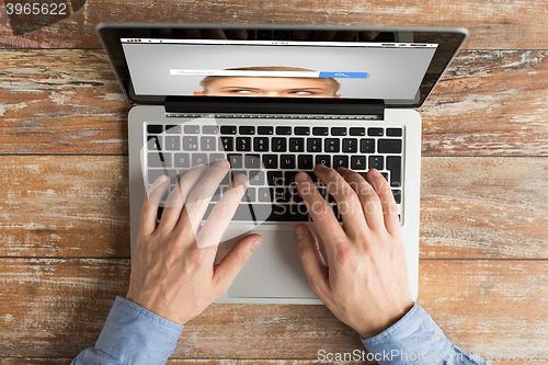 Image of close up of male hands with laptop typing