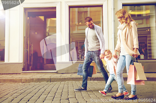 Image of happy family with child and shopping bags in city