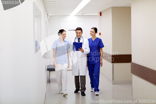 Image of group of smiling medics at hospital with clipboard