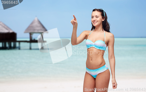 Image of happy woman in bikini swimsuit pointing finger