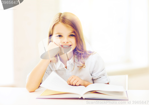 Image of little student girl studying at school