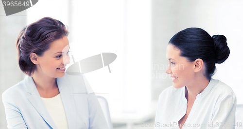 Image of two businesswomen having discussion in office