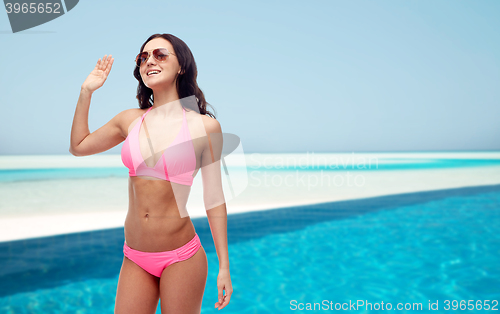 Image of happy woman in sunglasses and bikini on beach