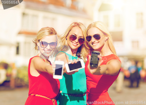 Image of beautiful girls with smartphones in the city